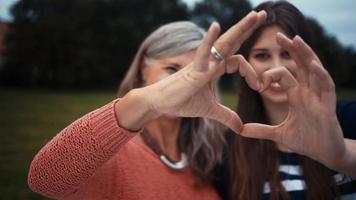 madre e figlia mostrano il cuore con le loro mani insieme