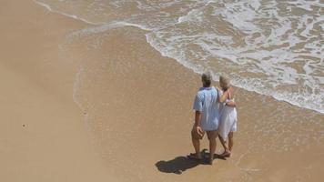 senior paar samen wandelen op het strand, de hoge mening van de hoek