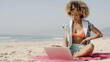 donna con il portatile sulla spiaggia estiva