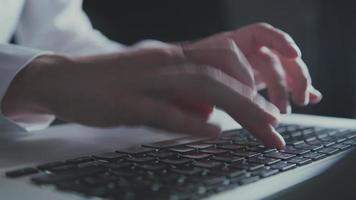kvinna händer i vit blus att skriva på tangentbordet i kvällsljuset video