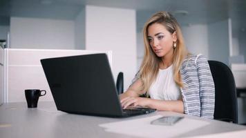 gelukkig zakenvrouw werkt op haar laptop op kantoor