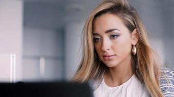 glad affärskvinna som arbetar på sin bärbara dator på kontoret