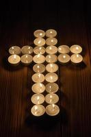Lit tea lights in the shape of a cross on