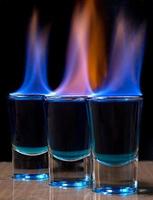 Burning drink in shot glass on a table photo