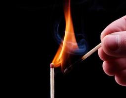 Ignition of a match, with smoke on dark background photo