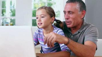farfar och flicka som använder bärbar dator