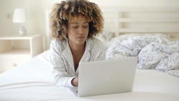 vrouw kijken naar laptop in bed thuis