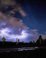 Lightning striking over a field photo