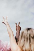 Two people giving the peace sign in the air