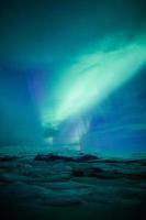 auroras boreales (aurora borealis) sobre una laguna en islandia foto