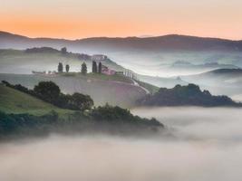 Tuscan fields wrapped in mist, Italy photo