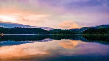 reflejo de una puesta de sol sobre un cuerpo de agua foto