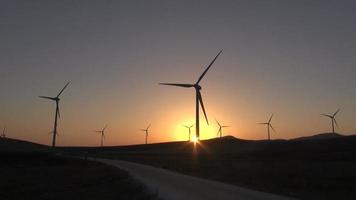 coucher ou lever de soleil dans le champ des turbines