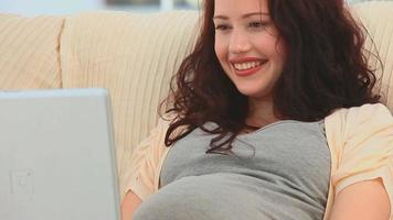 gravid kvinna som chattar på sin bärbara dator