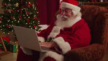 Santa Claus works on laptop computer video