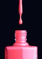 Nail varnish dripping from brush into bottle photo