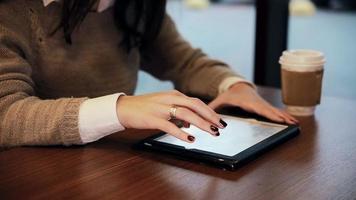 vrouw handen met behulp van touchscreen tablet in café