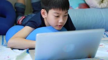 asiatischer Junge, der Spiele auf Laptop-Computer spielt. video
