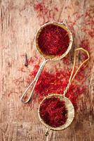 saffron spice in rustic sieve on old wooden background, closeup
