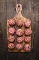 meat balls herbs onions  cutting board on wooden rustic background