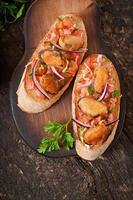 Bruschetta with mussels, cheese and tomatoes photo