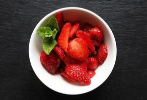 Cut strawberries in ceramic bowl photo