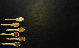 Powder spices in little wooden spoons photo