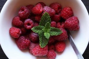 Raspberries in white ceramic bowl photo