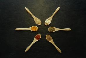 especias en polvo en cucharitas de madera foto