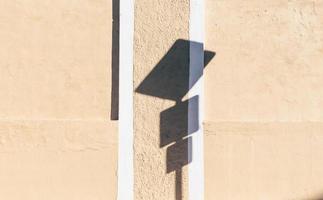 Road signage shadow on wall during the day photo