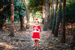 niña asiática en traje rojo de santa claus foto