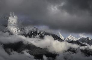 picos nevados bajo nubes oscuras en nepal foto