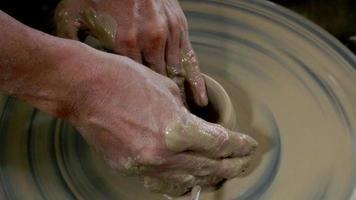 Man made the earthenware by mechanic pottery working with potter's wheel