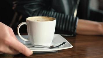 serveerster serveert warme koffie in restaurant