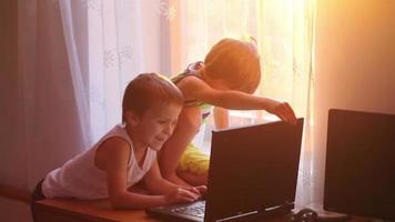 dos niños, jugando en la tableta a la hora del atardecer en casa video