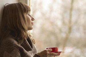 Beautiful girl dreaming with cup of coffee photo