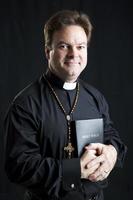 sacerdote con rosario y biblia foto