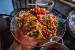 Beans and tomatoes on glass plate photo