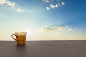 Coffee mug on the table with a view of the sky and clouds photo