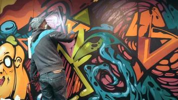 Graffiti artist painting on the wall, interior