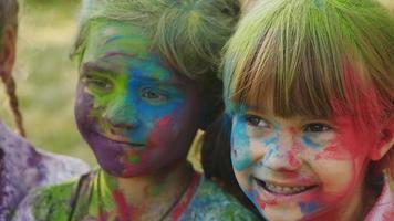 söta europeiska barnflickor firar indisk holifestival med färgglad färg video