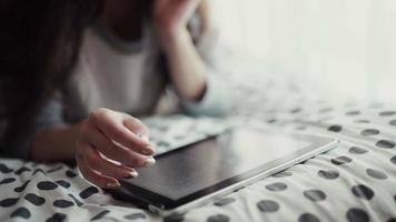 vrouw liggend in bed met digitale tablet aanraken met vinger. uitzicht van boven video