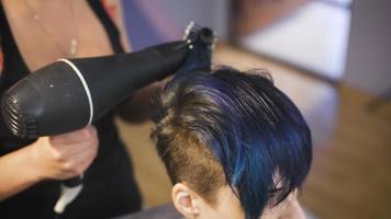 The girl with blue hair in a beauty salon video