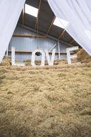 LOVE letters set up on a haystack at wedding location photo