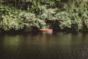 Red canoe on the river bank photo