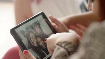 Famille regardant des photos sur une tablette dans la salle de séjour