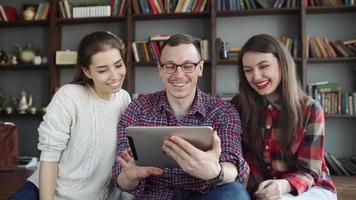 group of smiling friends with tablet