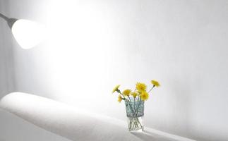 Yellow flowers in clear glass vase photo