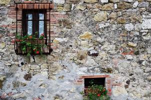 Black wooden window panels on cobblestone wall photo