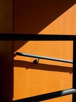 Shadows of rail on orange wall photo